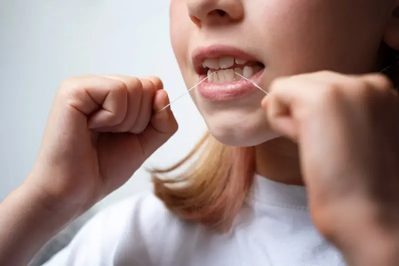 Flossing - menghilangkan karang gigi dengan benang gigi